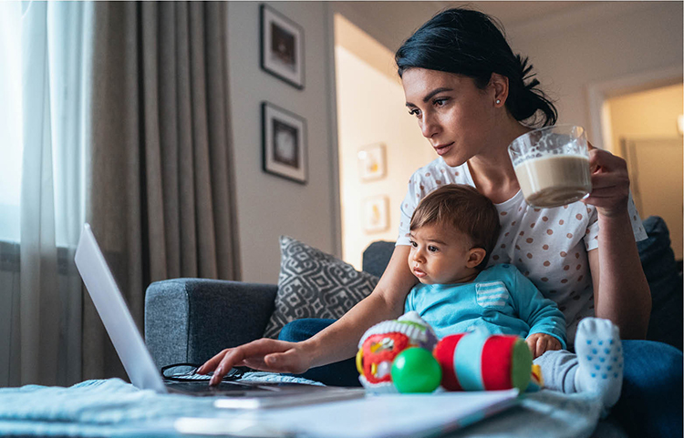 Femme tenant un bébé et consultant son relevé bancaire en ligne